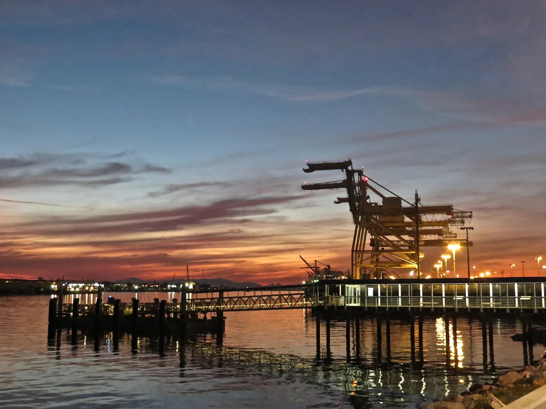 Luz del atardecer sobre el puerto en actividad de Oakland y el muelle de Jack London Square.