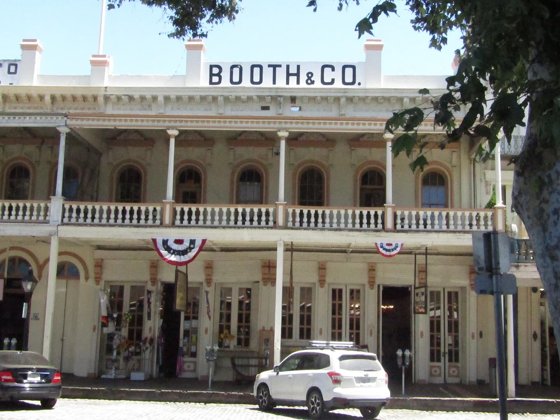 Fachadas comerciales históricas de madera con balcones cubiertos en una calle de Old Sacramento.