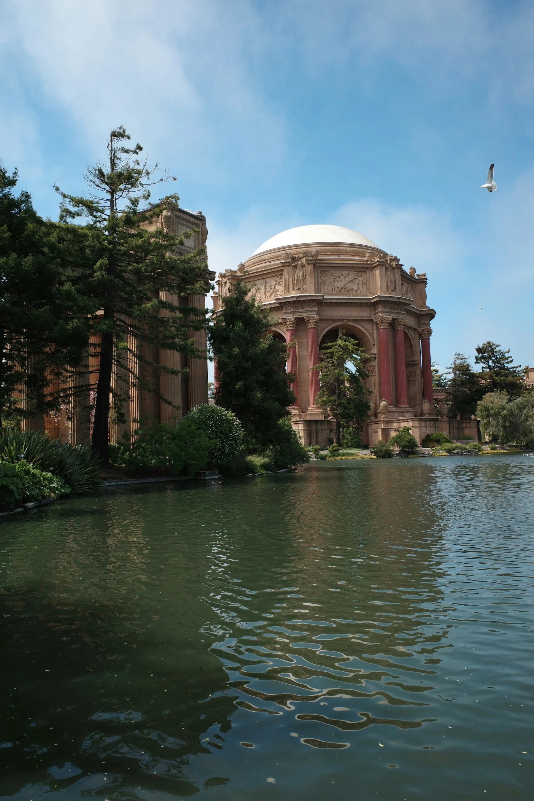 The Palace of Fine Arts rotunda and colonnades reflected beside a tree-lined lagoon