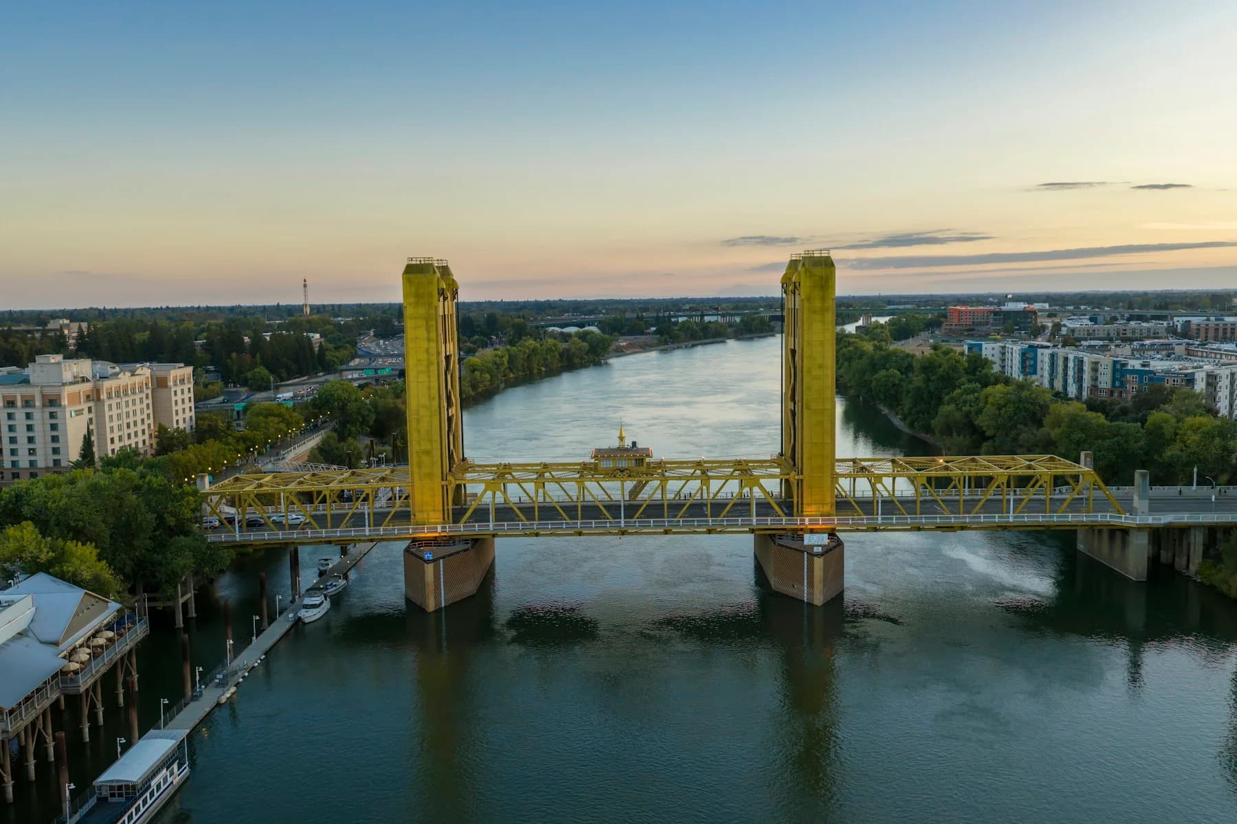 Aerial view of the full yellow Tower Bridge over the Sacramento River at sunset