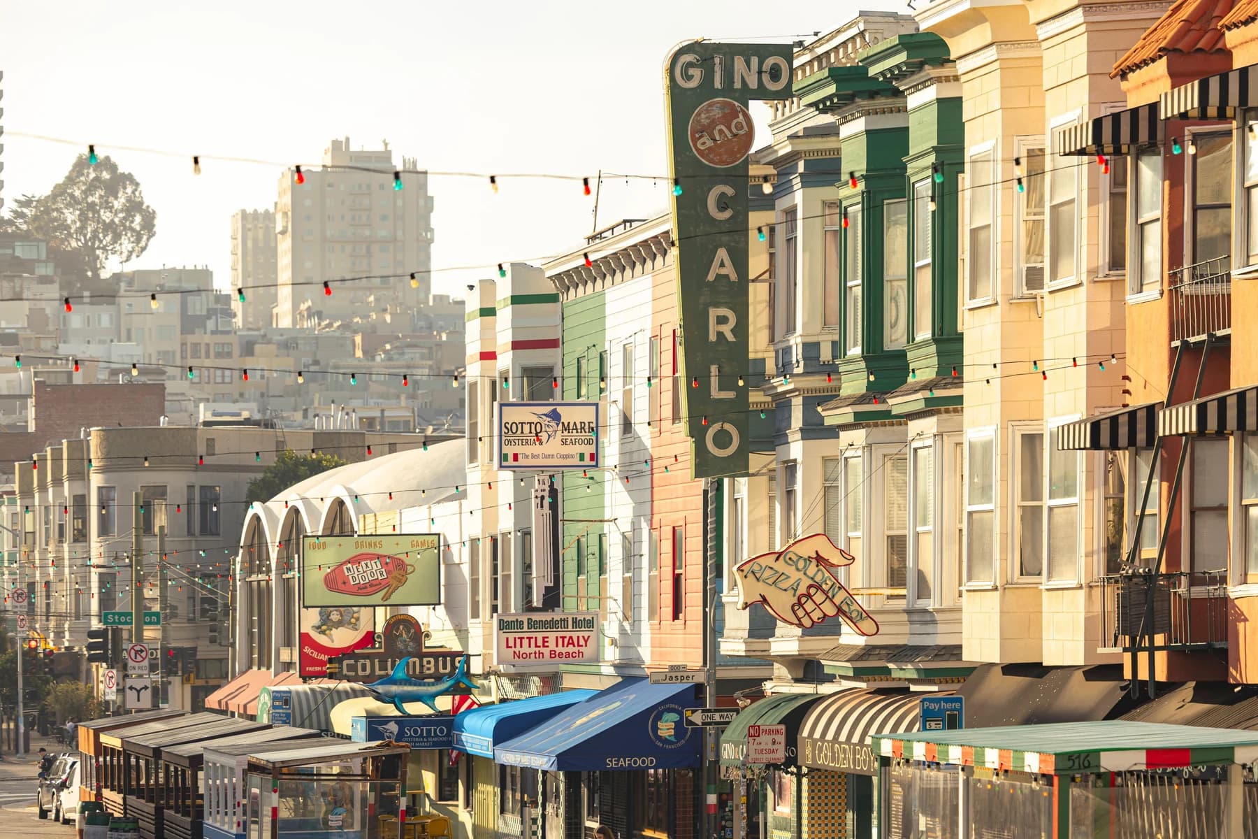 Restaurantes y fachadas comerciales de colores en Green Street, North Beach, con la luz cálida del atardecer
